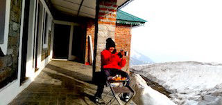 hiker enjoying tea and snacks at triund top